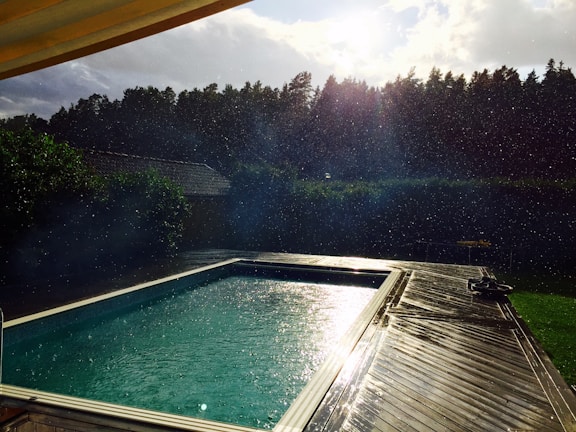 A freshly completed vinyl liner pool shimmering under the Tennessee sun, surrounded by a family enjoying the water.