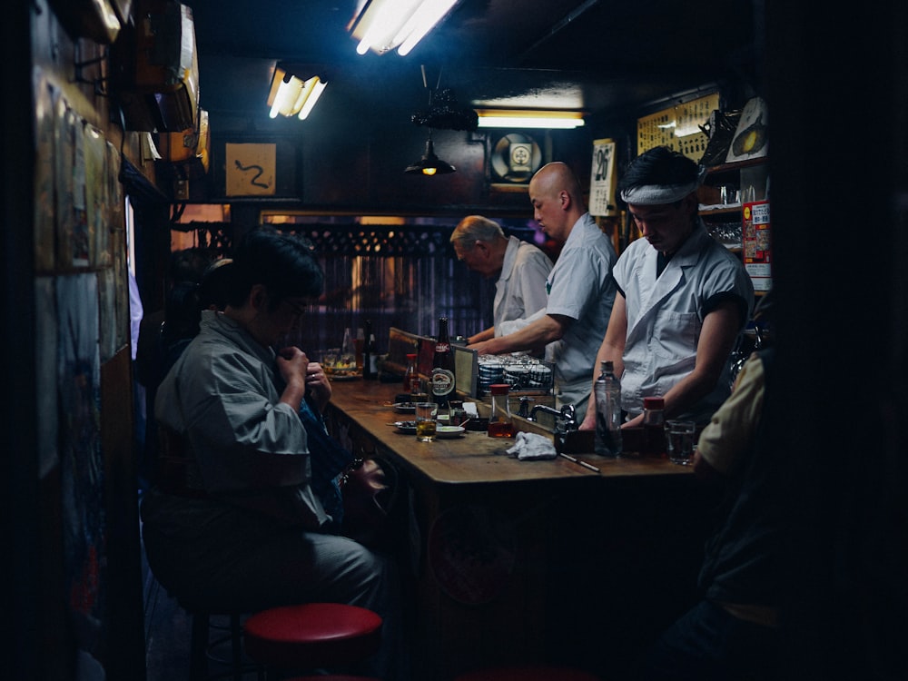 a group of people sitting around a bar