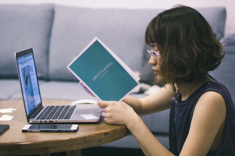 a woman sitting at a table with a laptop