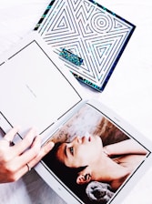 Close-up of hands flipping through a beautifully designed art book featuring contemporary Argentine women artists.
