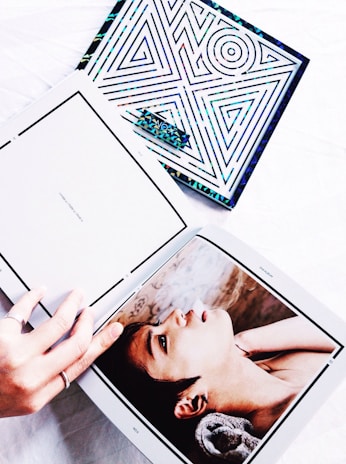 Close-up of hands flipping through a beautifully designed art book featuring contemporary Argentine women artists.