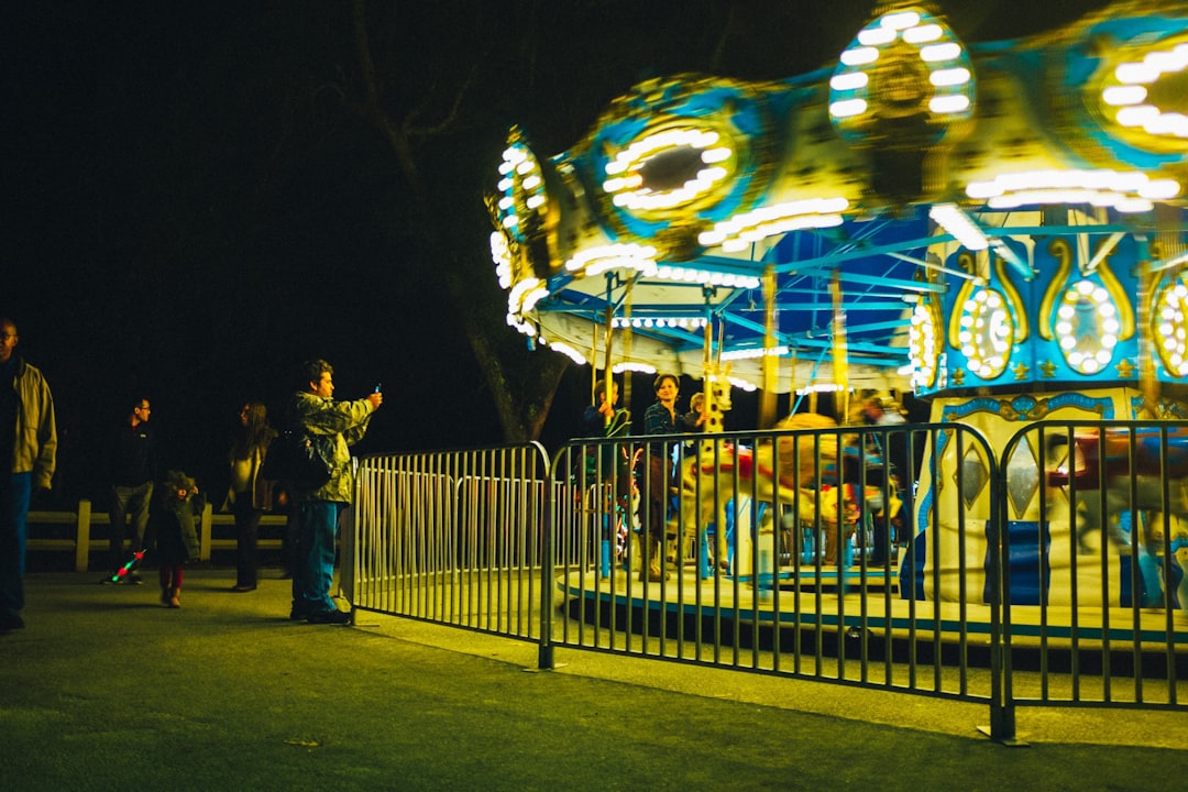 people standing near white and blue carousel during night time