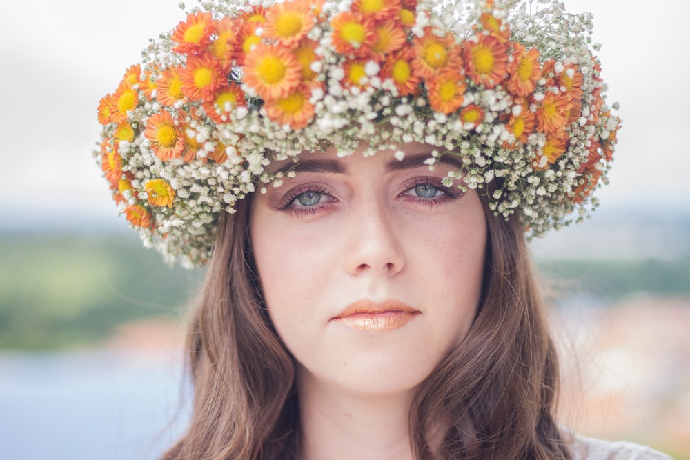 Frau mit orangefarbenem und weißem Blumenkopfschmuck