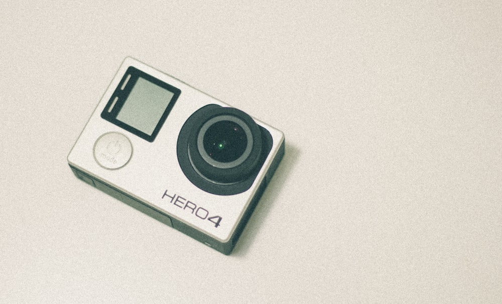 A GoPro Hero4 camera sitting on a white surface.