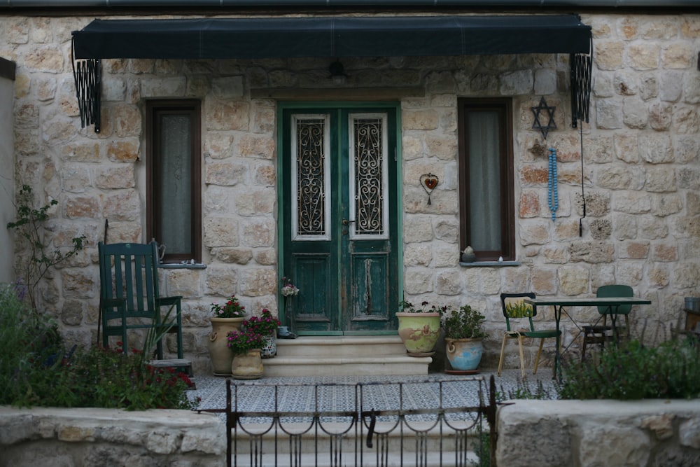 Maison en brique avec portes vertes et portail en métal noir