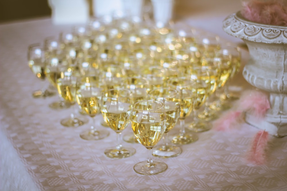 clear wine glass lot filled with yellow liquid