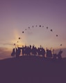 silhouette of people standing on hill