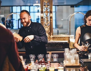 photo of man and woman mixing beverages