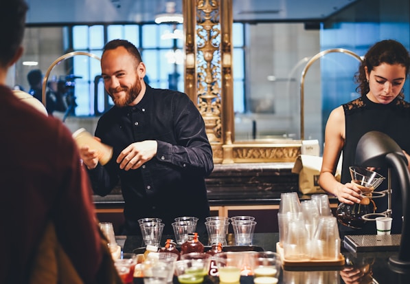 photo of man and woman mixing beverages