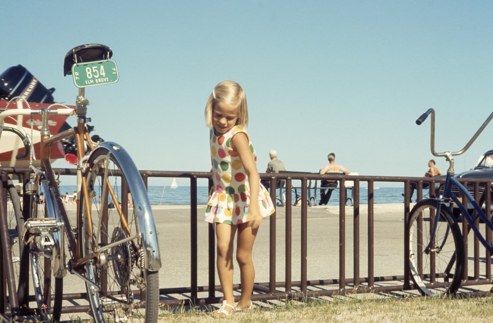 muchacha de pie cerca de la bicicleta