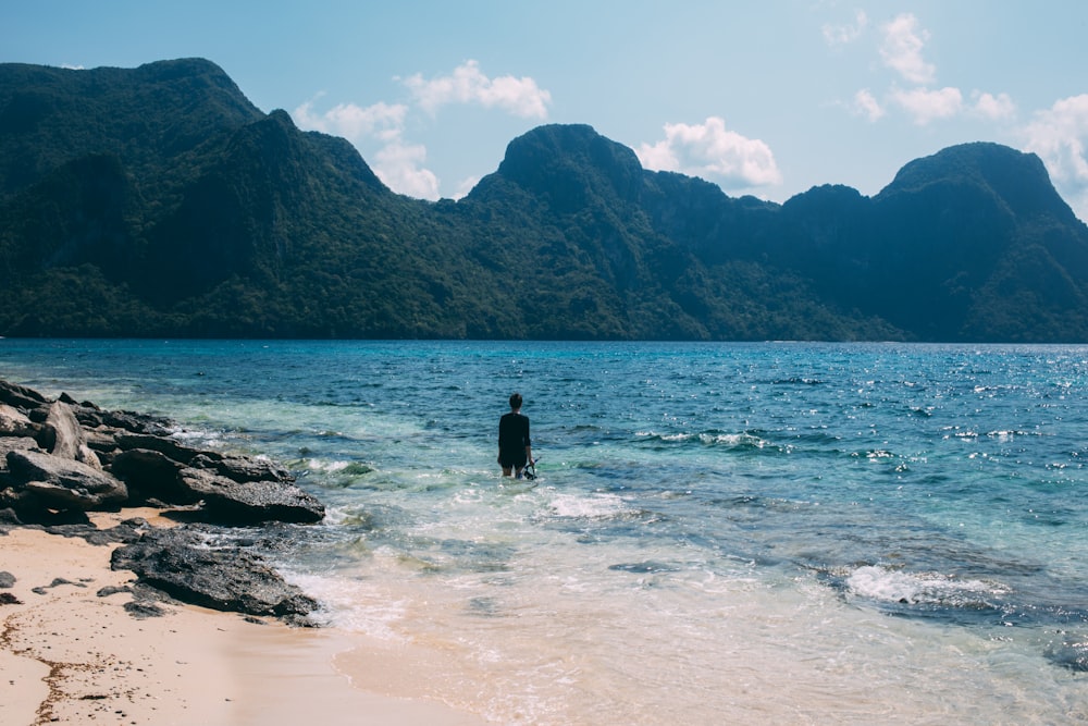 a person standing in the water at a beach