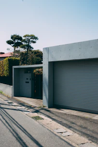 A modern accessory dwelling unit nestled in a sunny backyard with beige and grey tones.