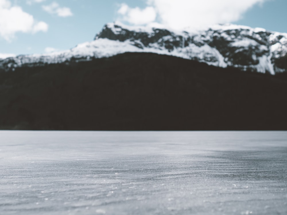 a snow covered field with a mountain in the background