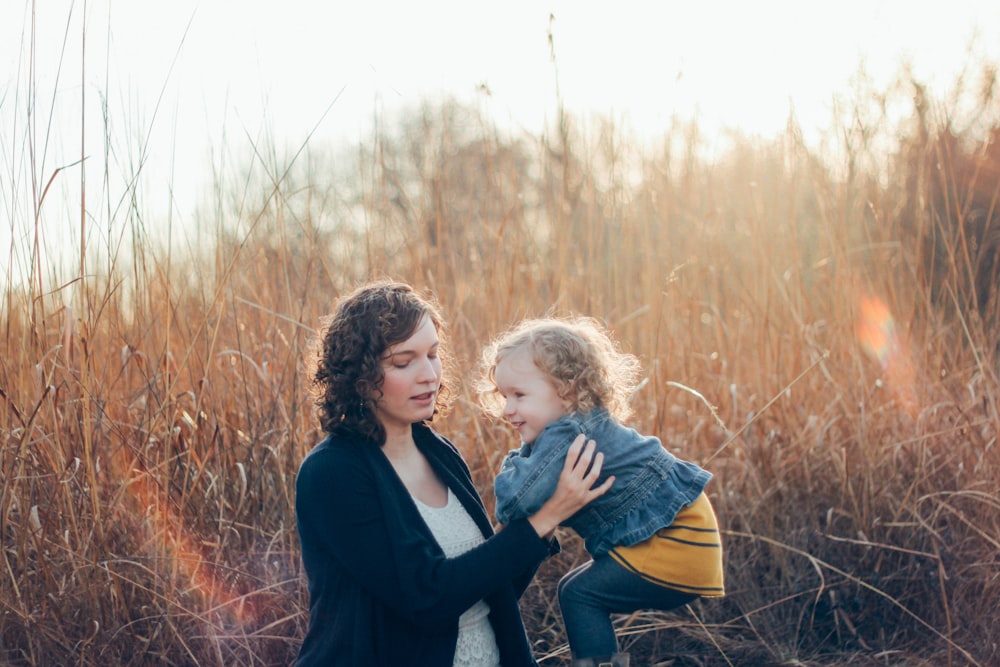 photo of woman carrying girl