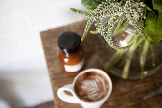Close-up of a sleek wooden coffee table with a vase of fresh flowers on top.