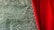 A luxurious deep red velvet curtain partially covers a background of textured green marble. The marble features intricate white veining, adding a sophisticated touch to the scene.