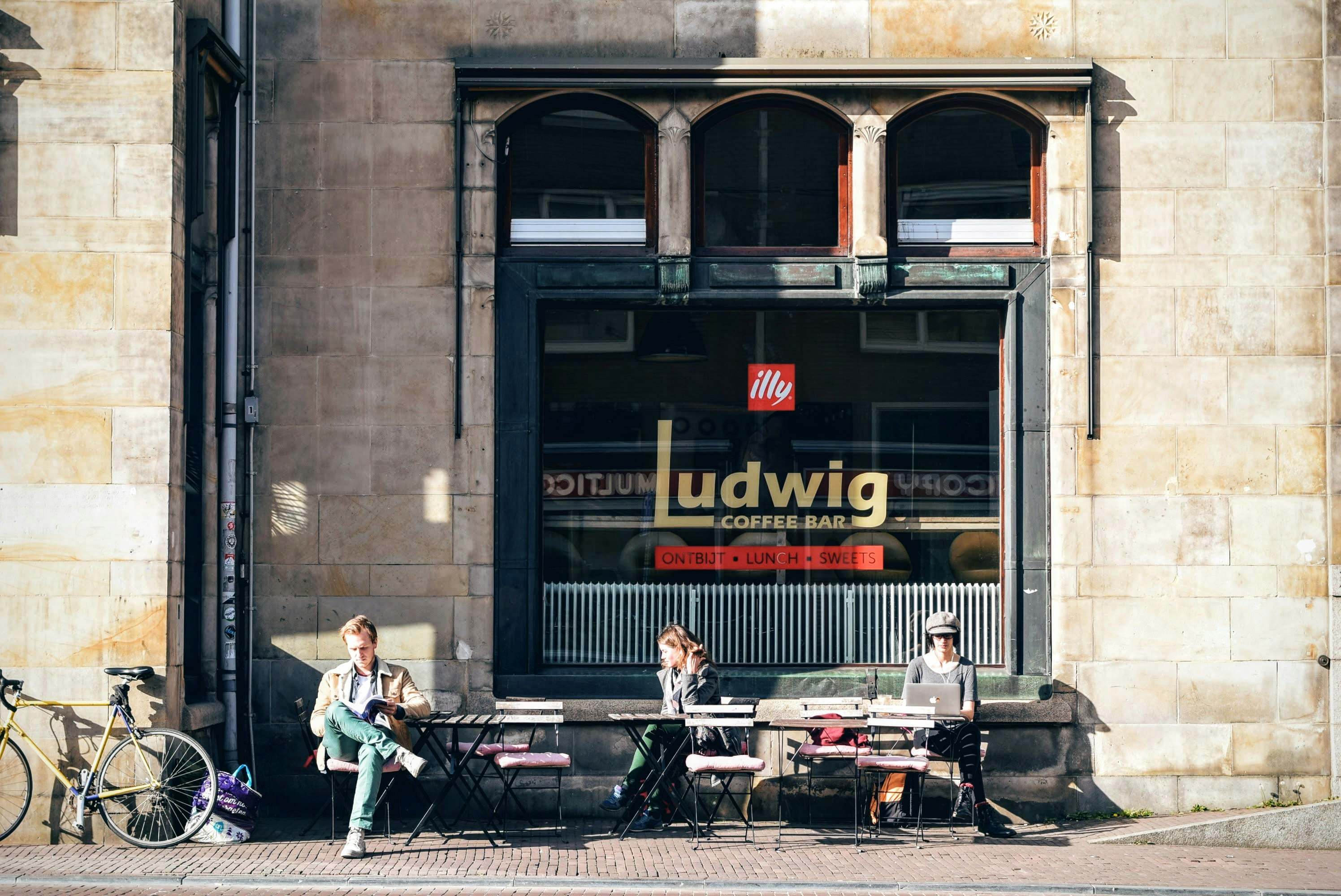 three person sitting on outdoor chair in front Ludwig cafe