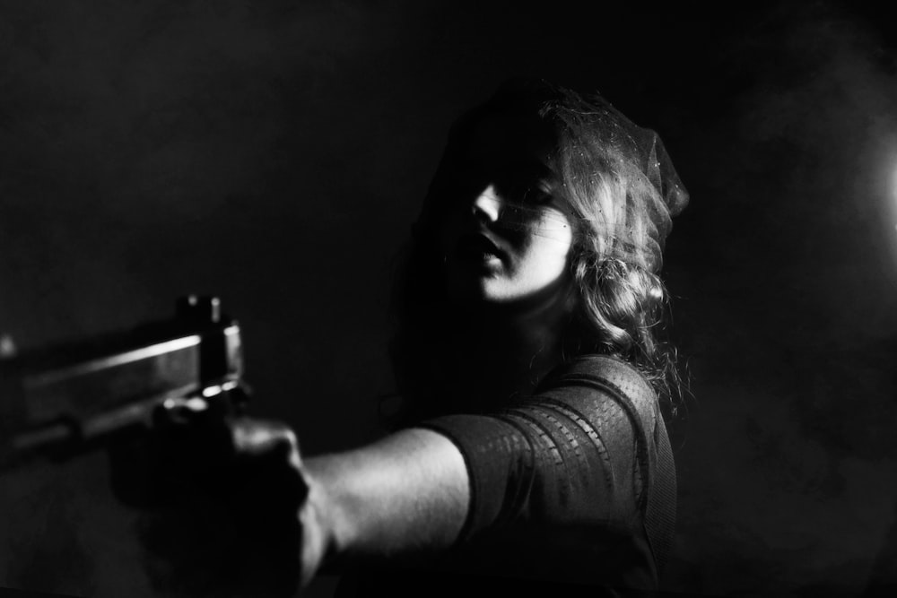 femme tenant un pistolet