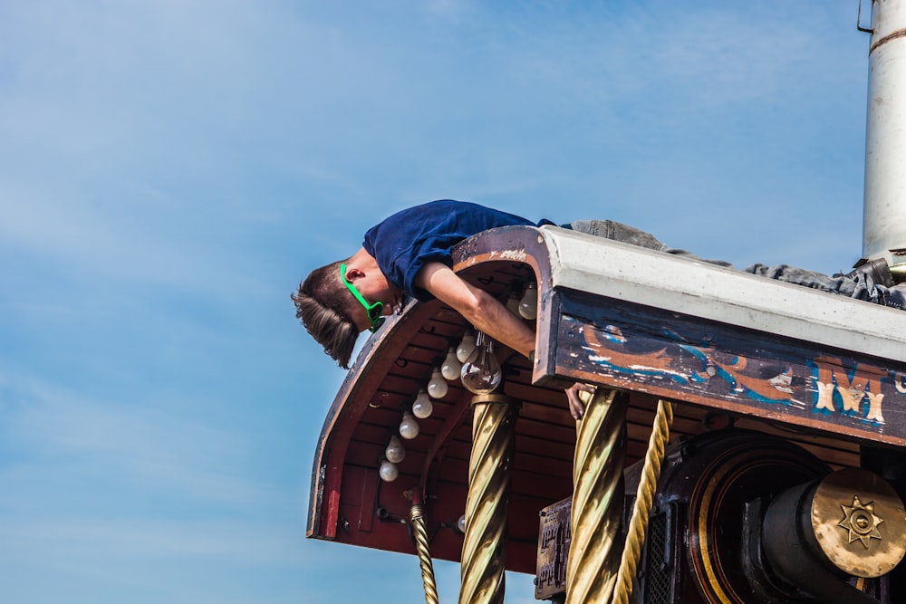 man on top of metal roof at daytime