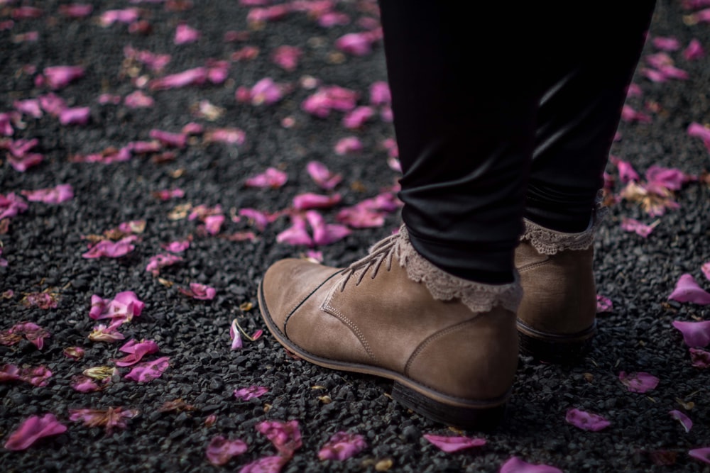 persona con zapatos de cuero marrón