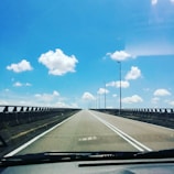 Close-up on a truck's dashboard with the road stretching ahead under clear skies.