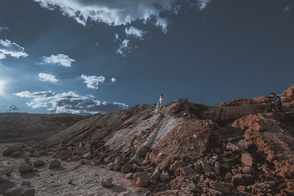 Persona in piedi sulle cime della formazione rocciosa durante il giorno