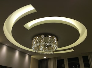 Elegant modern ceiling with intricate staff work in a bright living room