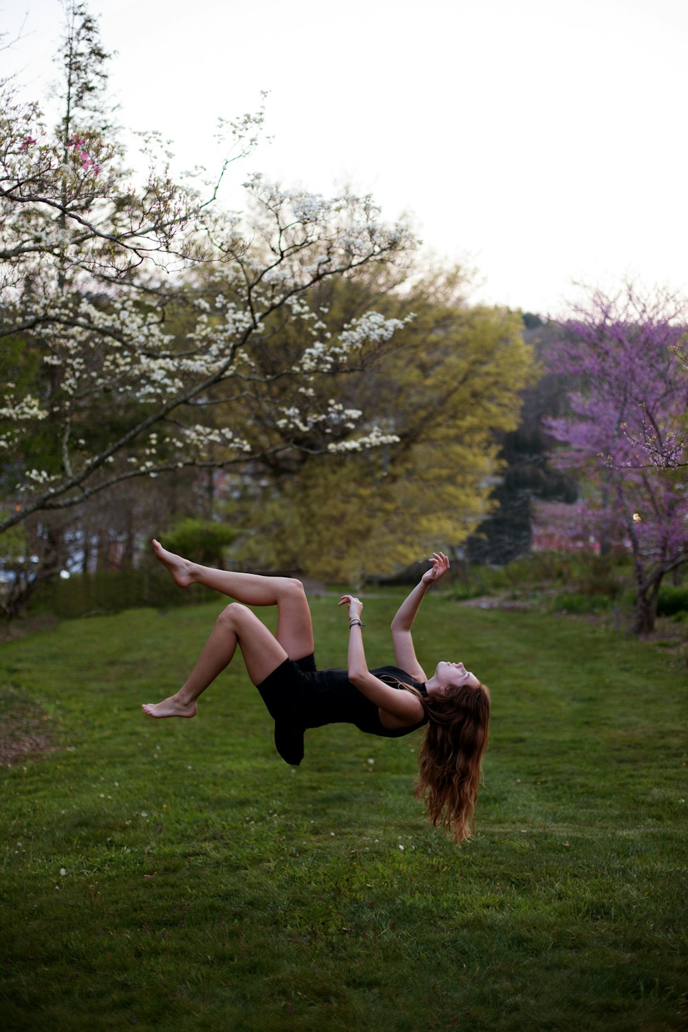 woman back flipping in the garden