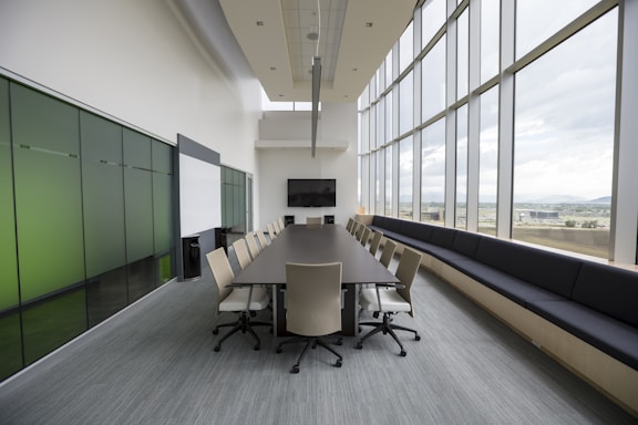 An clean office boardroom with mopped floors and wiped tables and chairs. Clean windows on the right