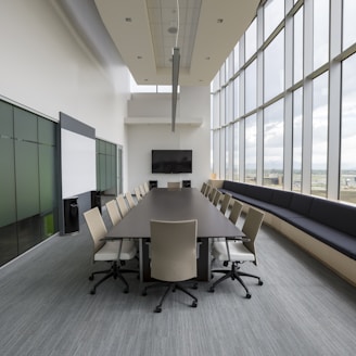 rectangular brown wooden table with chair lot inside building