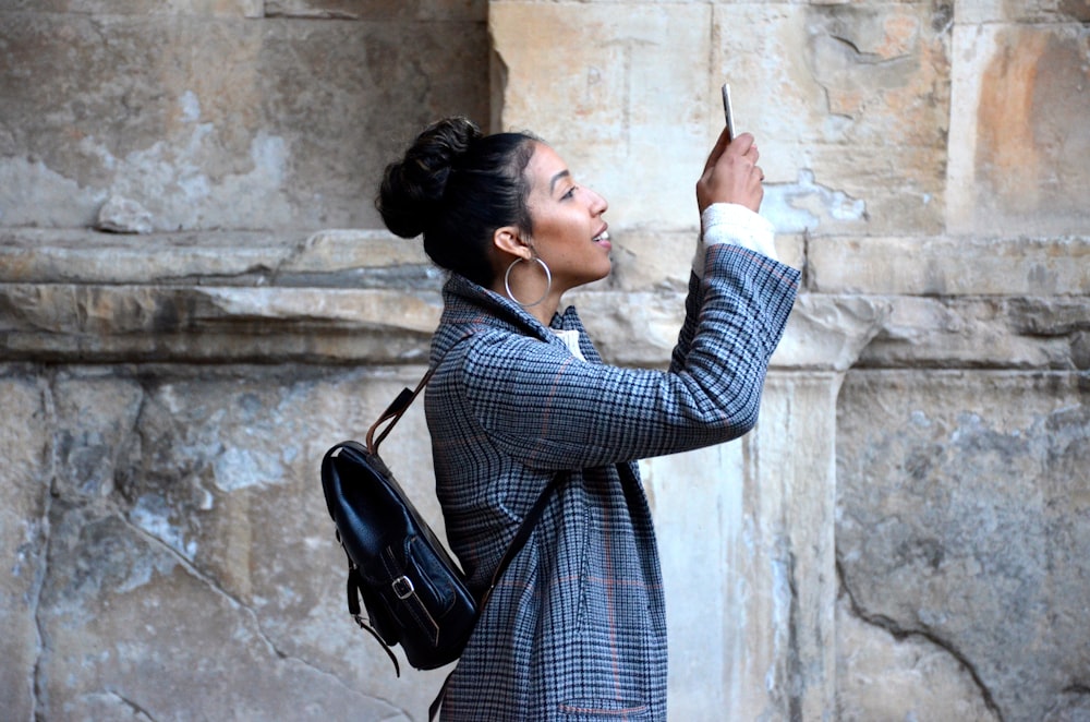 woman wearing blue shirt while looking at her phone