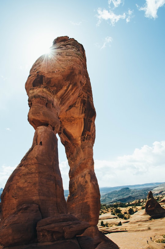 brown boulder near canyon under blue sky in Arches National Park United States