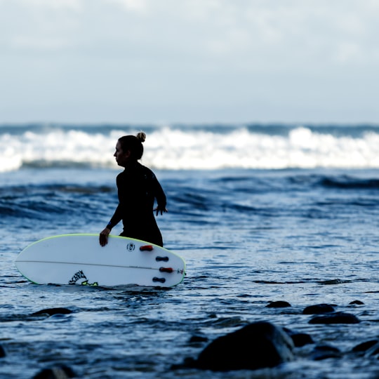 woman holding white surfboard on body of water in Malibu United States