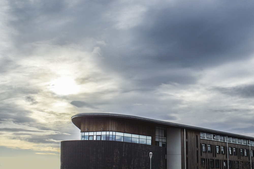 black and brown concrete building under gray cloudy sky