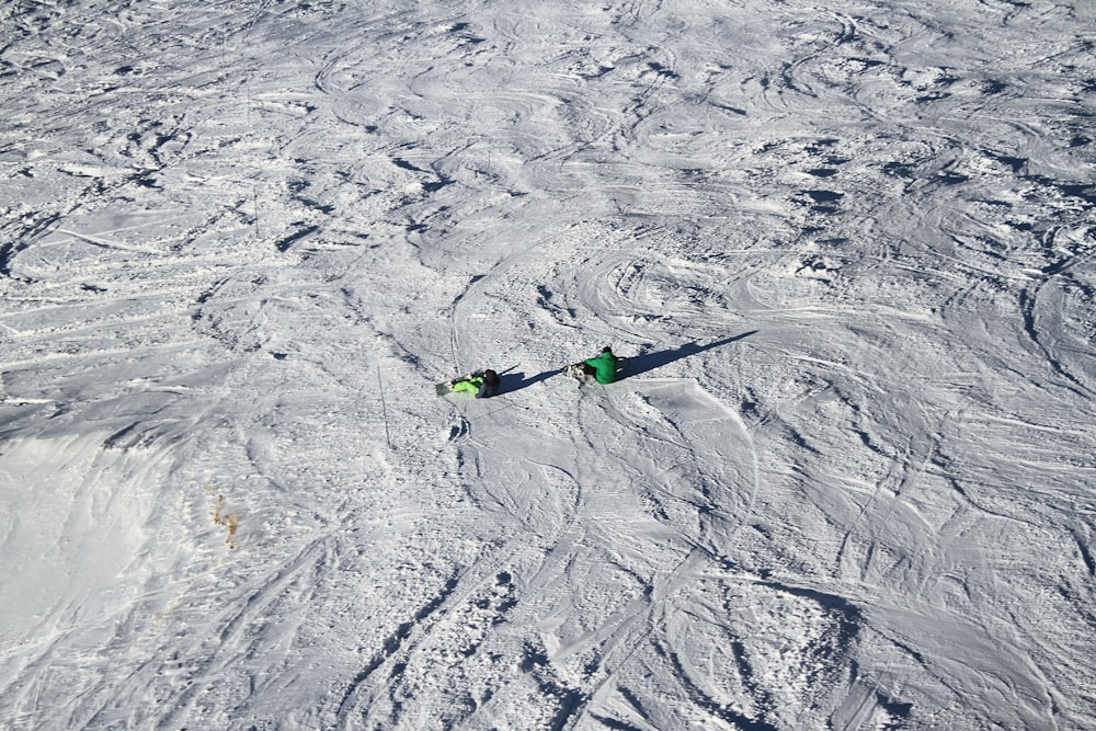 persona sentada en un campo cubierto de nieve