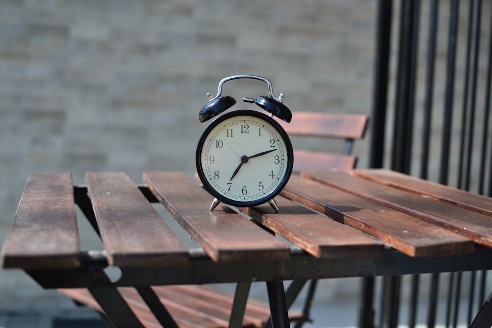 갈색 테이블 위에 검은 강철 알람 시계