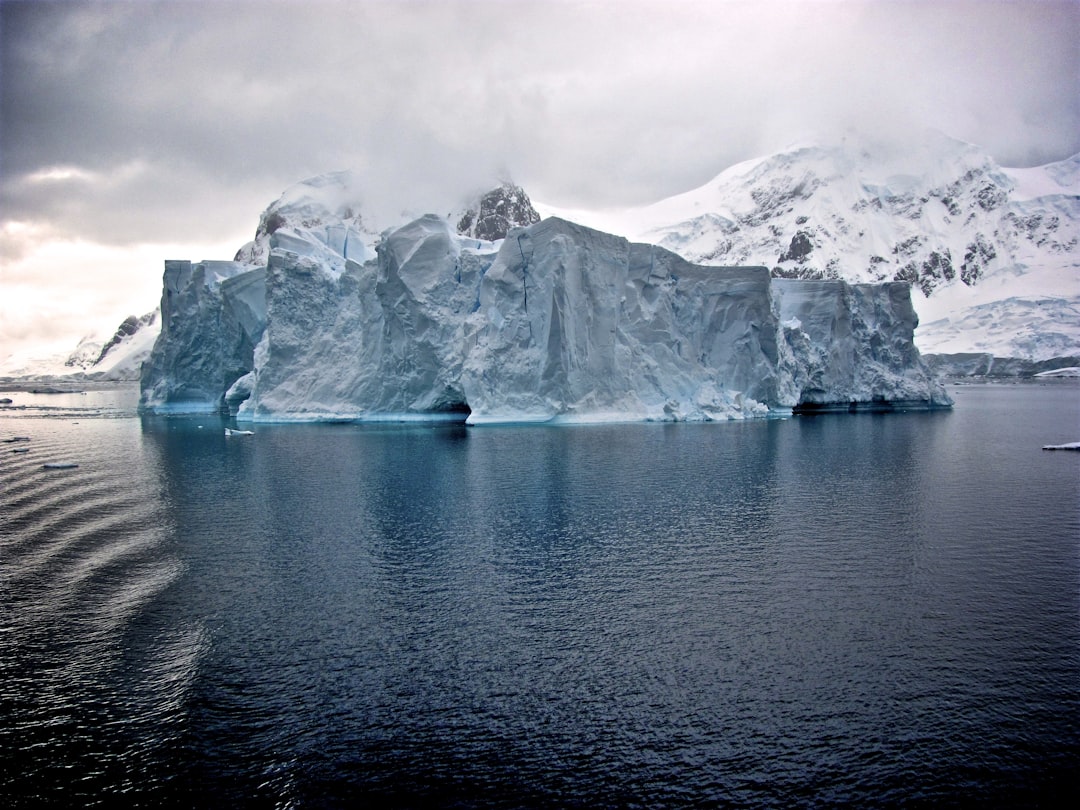 white iceberg near white mountains,
