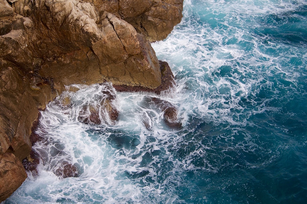 body of water near brown rock formation during daytime