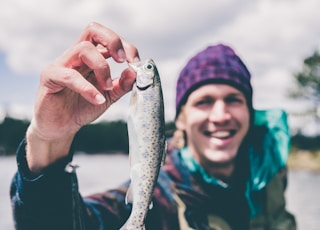 depth photography of man holding fish