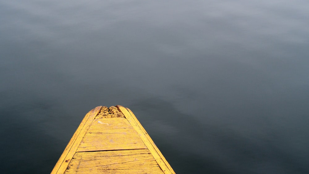 a yellow boat floating on top of a body of water