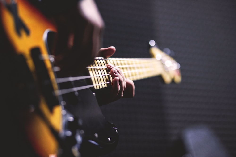 closeup photo of person playing guitar