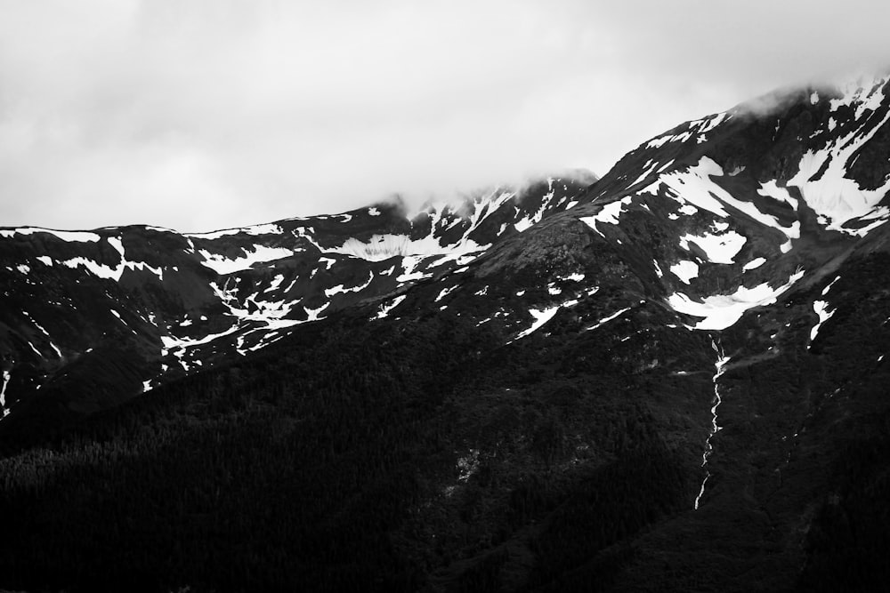 Uma foto em preto e branco de montanhas cobertas de neve