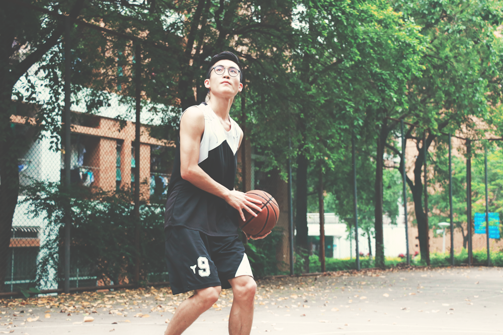 hombre sosteniendo una pelota de baloncesto roja