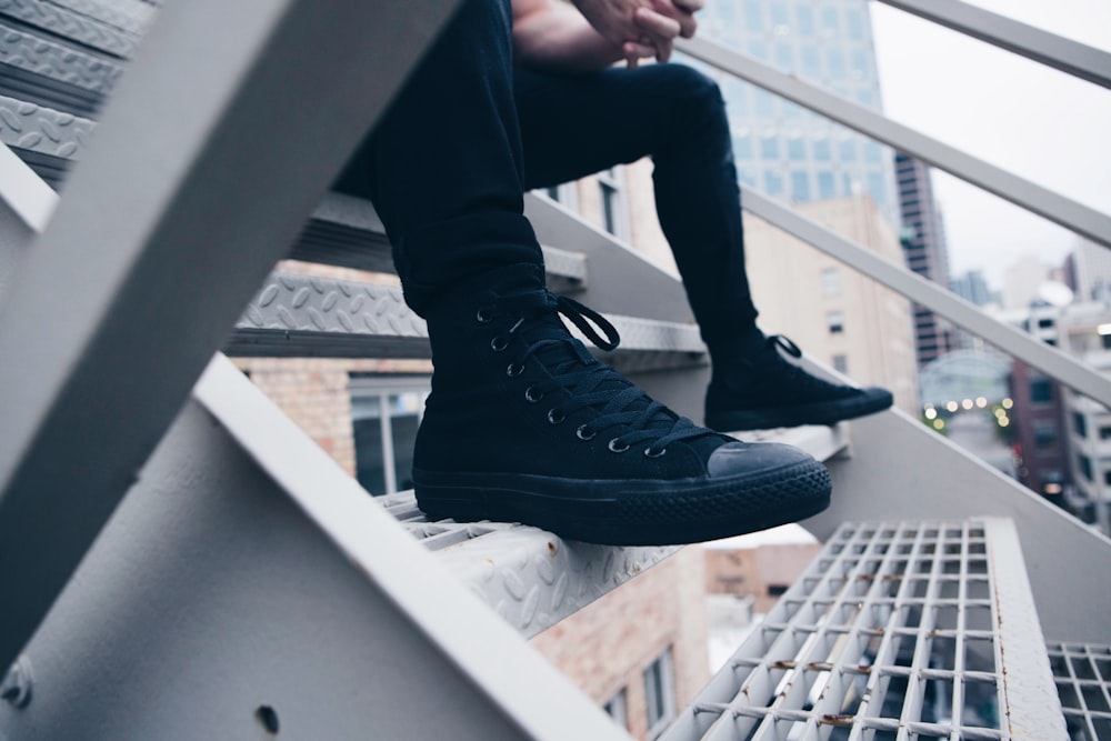 person sitting on gray stair