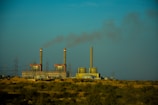 Industrial plant with smokestacks emitting minimal emissions under a clear blue sky.
