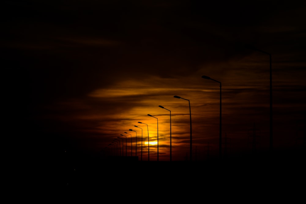 luzes de rua silhueta durante o pôr do sol