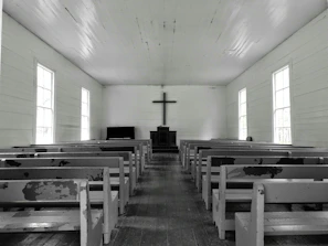 A calm church interior with empty wooden pews and a pulpit ready for service