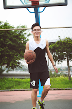 Athlete lacing up wrist braces before a basketball game on an outdoor court.