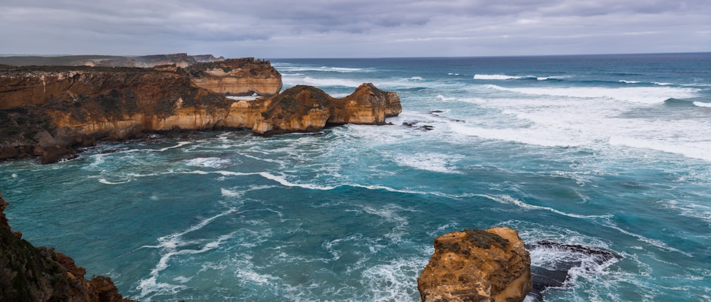 brown rock formation on sea during daytime