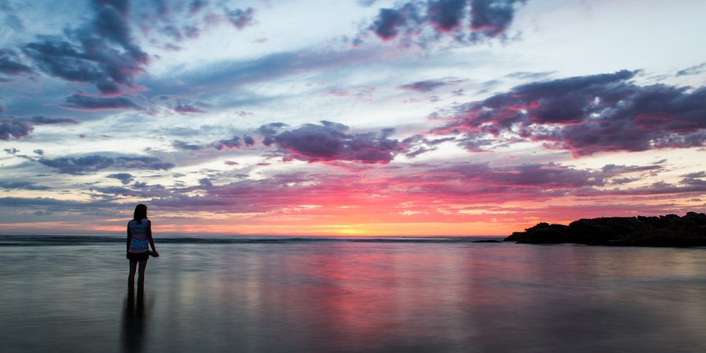 body of water under cloudy sky during sunset